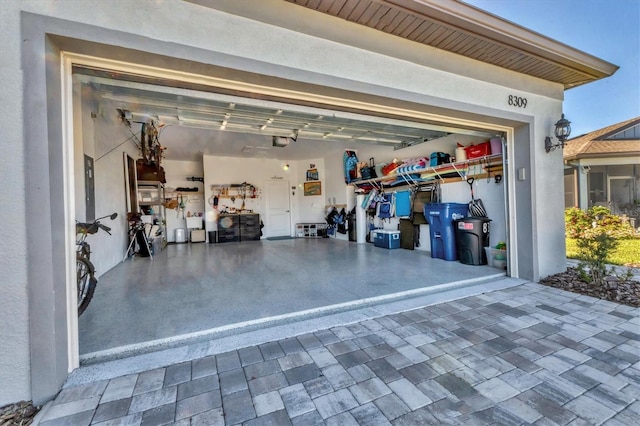 garage with a garage door opener and decorative driveway