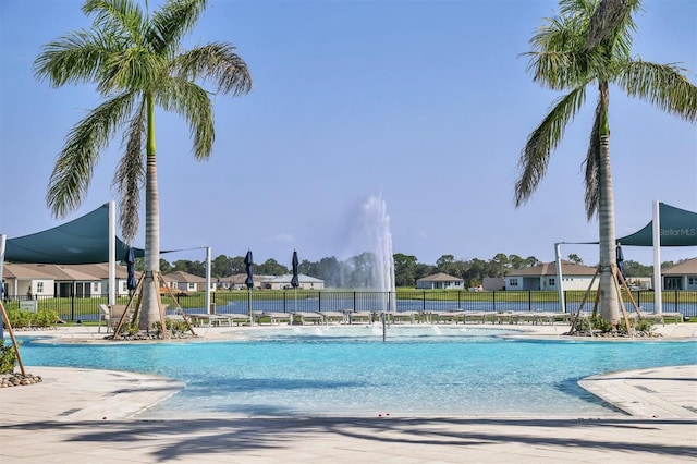 view of swimming pool featuring fence