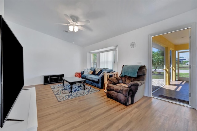 living room with wood finished floors, a ceiling fan, visible vents, and vaulted ceiling