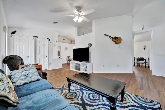 living area with visible vents, wood finished floors, baseboards, lofted ceiling, and ceiling fan