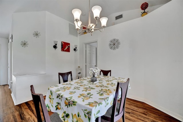 dining room featuring visible vents, wood finished floors, baseboards, and a chandelier