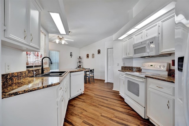 kitchen with a sink, white appliances, white cabinets, and light wood finished floors