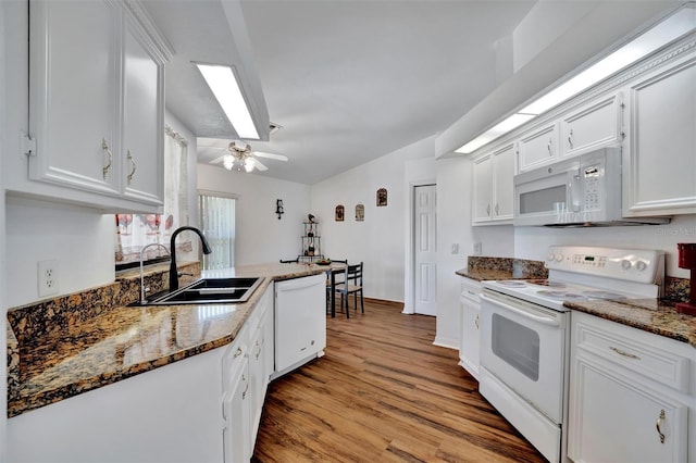 kitchen featuring white appliances, white cabinets, light wood-style floors, and a sink