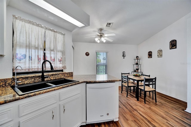 kitchen featuring wood finished floors, visible vents, white dishwasher, ceiling fan, and a sink