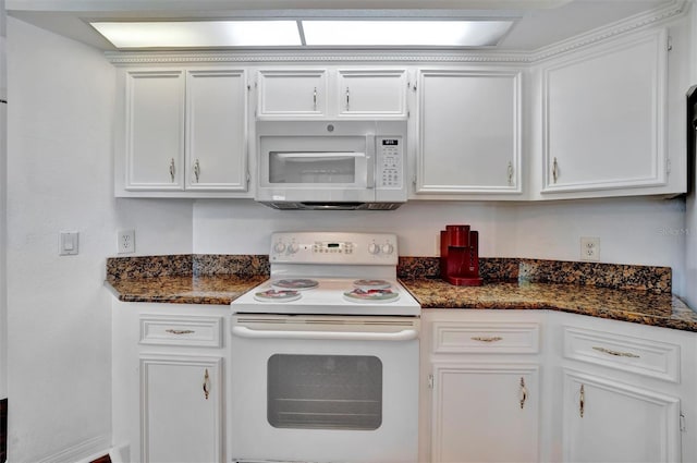 kitchen with dark stone counters, white appliances, and white cabinets