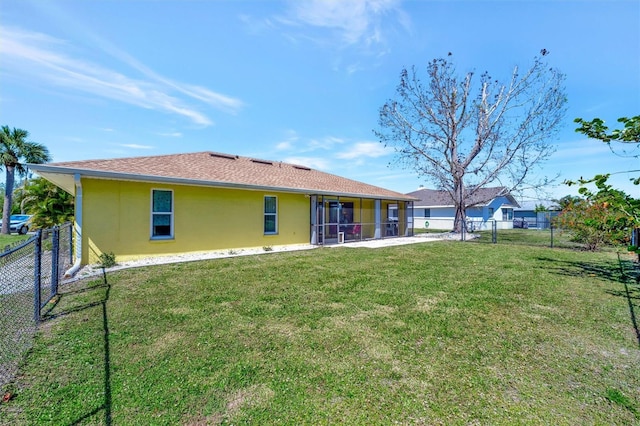 rear view of property with stucco siding, a lawn, a fenced backyard, and a sunroom