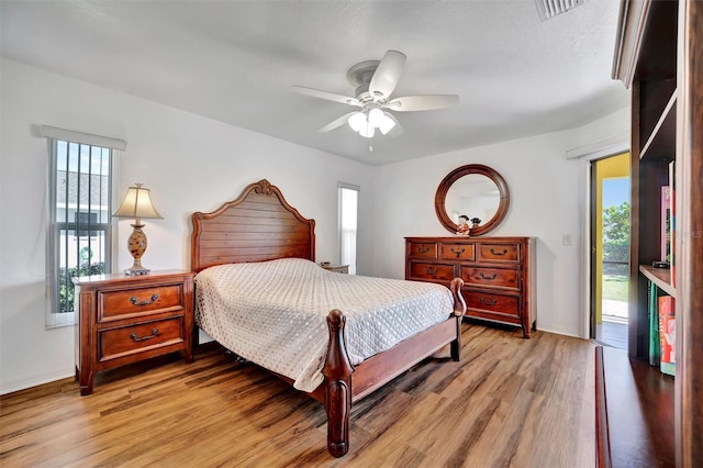 bedroom with access to outside, multiple windows, visible vents, and light wood-type flooring