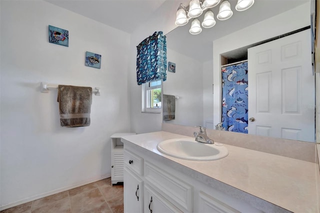 full bath with a chandelier, tile patterned flooring, vanity, and baseboards