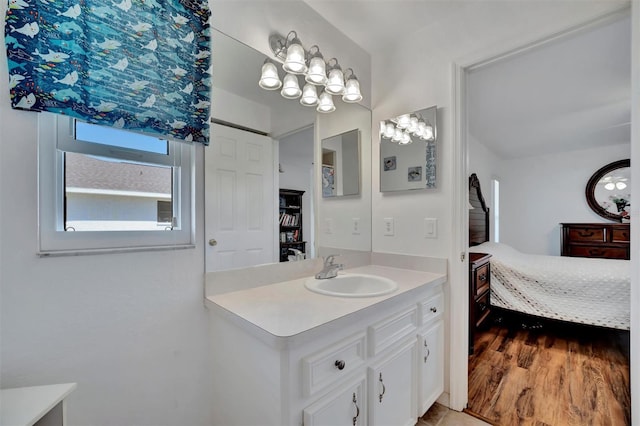 ensuite bathroom featuring vanity, ensuite bathroom, and wood finished floors