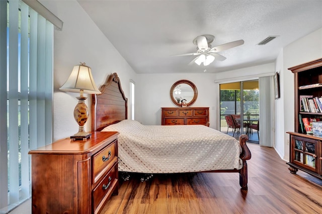 bedroom with wood finished floors, visible vents, ceiling fan, a textured ceiling, and access to outside