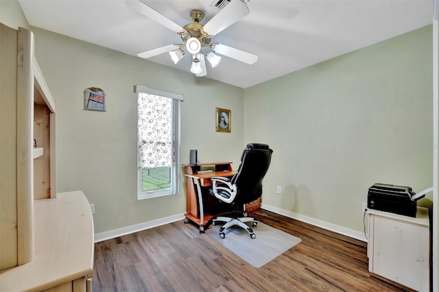 office space with baseboards, wood finished floors, and a ceiling fan