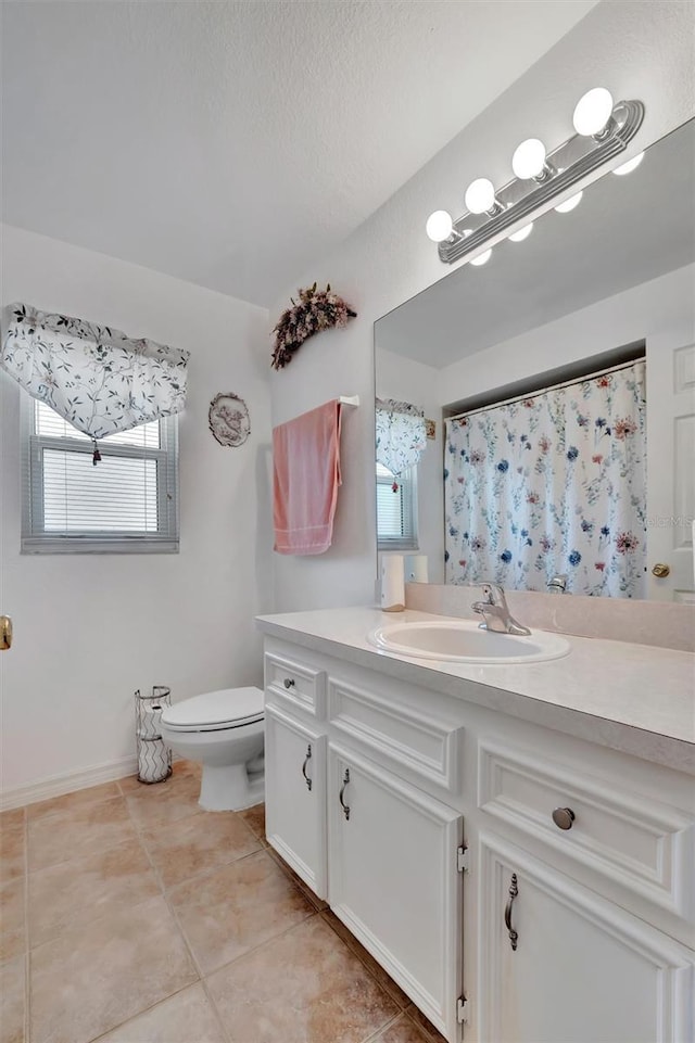 full bathroom with tile patterned flooring, plenty of natural light, toilet, and vanity