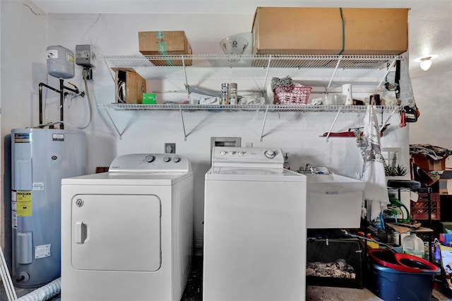 laundry area featuring a sink, water heater, laundry area, and washer and clothes dryer