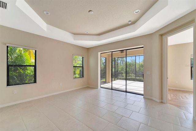 324 Casalino Dr, Nokomis, FL 34275 - spare room featuring a tray ceiling, light tile patterned floors, and baseboards