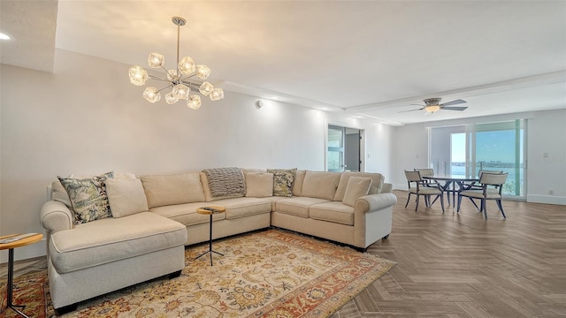 living area with ceiling fan with notable chandelier and baseboards