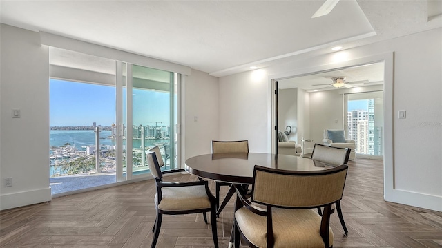 dining area with a ceiling fan and baseboards