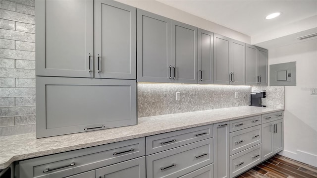 kitchen with dark wood finished floors, decorative backsplash, gray cabinetry, and visible vents