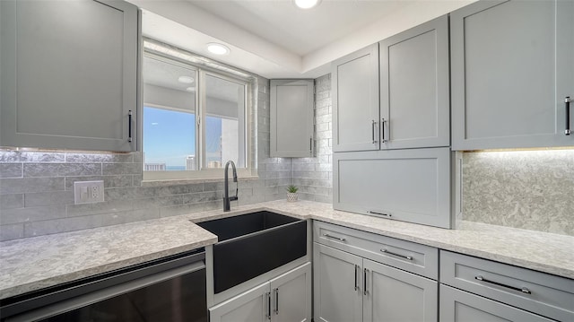 kitchen featuring recessed lighting, backsplash, gray cabinets, and a sink