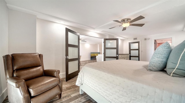 bedroom with a ceiling fan, baseboards, visible vents, wood tiled floor, and vaulted ceiling