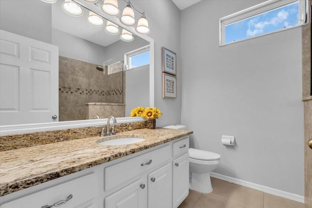 full bath with a wealth of natural light, walk in shower, vanity, and tile patterned flooring