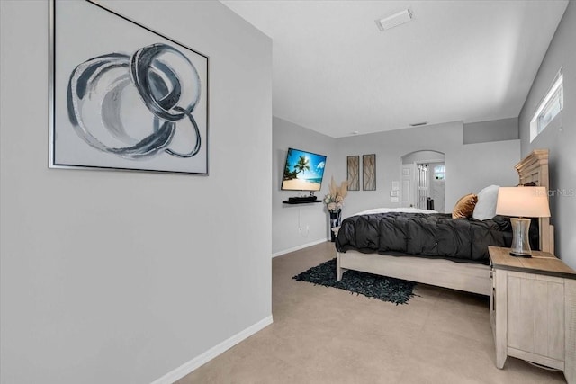 bedroom featuring arched walkways and baseboards