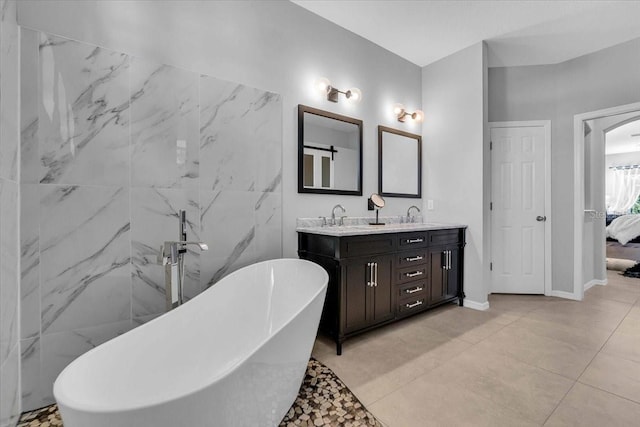 ensuite bathroom with a sink, a freestanding tub, ensuite bath, and double vanity