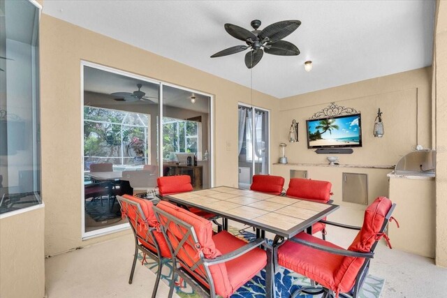 dining area featuring a ceiling fan and a sunroom