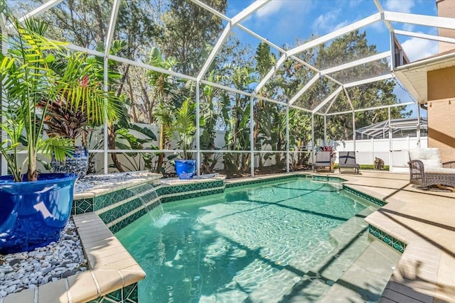 view of swimming pool featuring glass enclosure, a patio area, a fenced backyard, and a fenced in pool