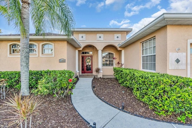 doorway to property featuring stucco siding