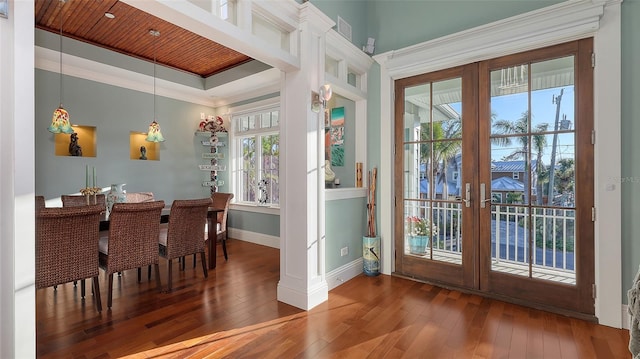 dining room with baseboards, ornamental molding, wood ceiling, french doors, and wood-type flooring