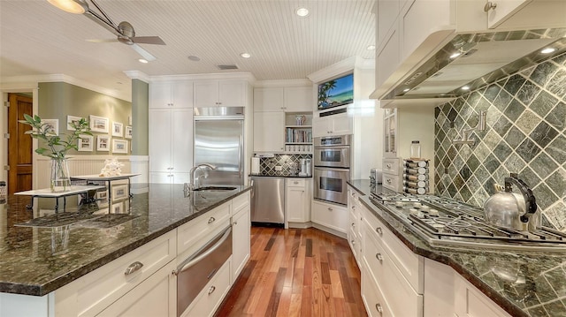 kitchen with a sink, under cabinet range hood, stainless steel appliances, a warming drawer, and open shelves