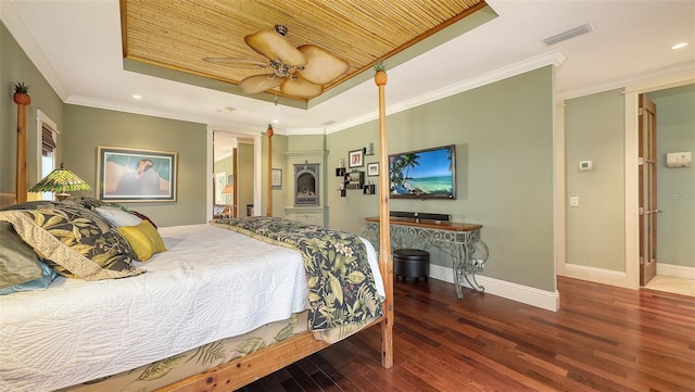 bedroom featuring visible vents, baseboards, ornamental molding, wood finished floors, and a raised ceiling