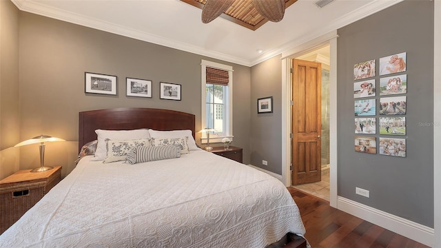 bedroom with ornamental molding, connected bathroom, baseboards, and wood finished floors