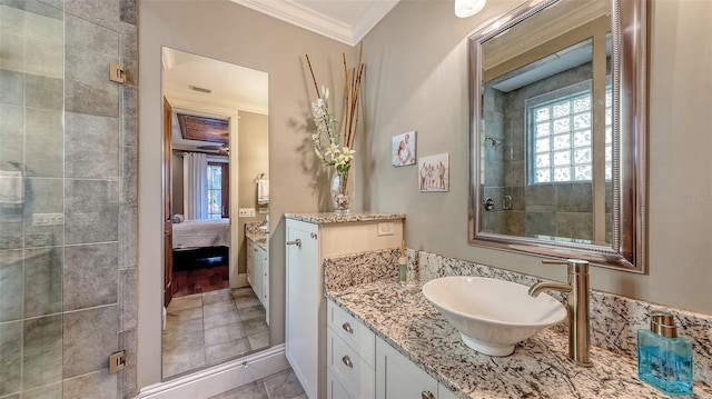 ensuite bathroom with vanity, a tile shower, ornamental molding, tile patterned floors, and connected bathroom