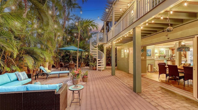 deck featuring outdoor lounge area, outdoor dining space, and stairs