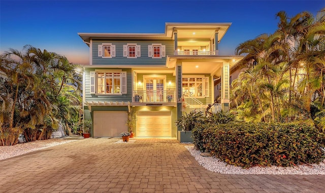 view of front of house featuring a balcony, decorative driveway, and an attached garage