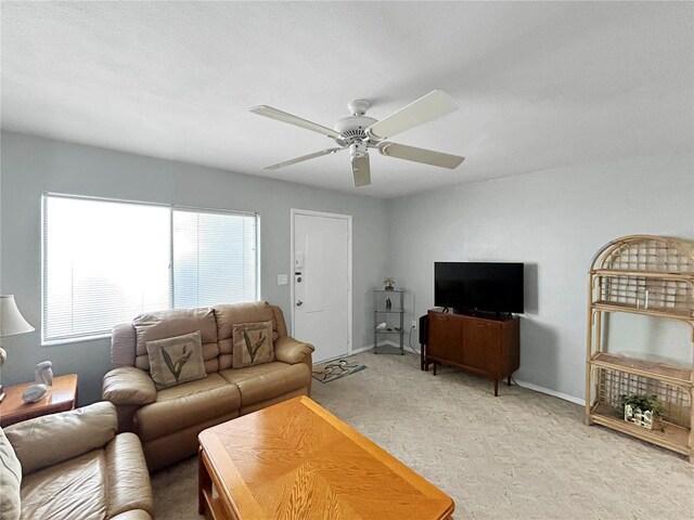 living room with light colored carpet, baseboards, and ceiling fan