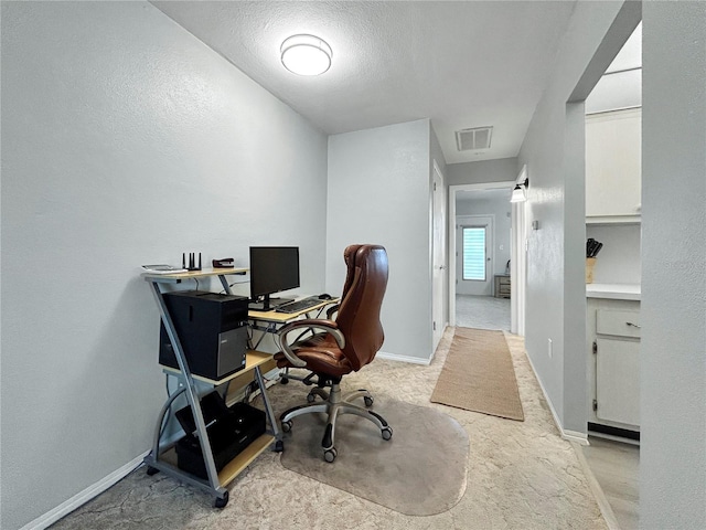 home office with visible vents, baseboards, light colored carpet, and a textured ceiling