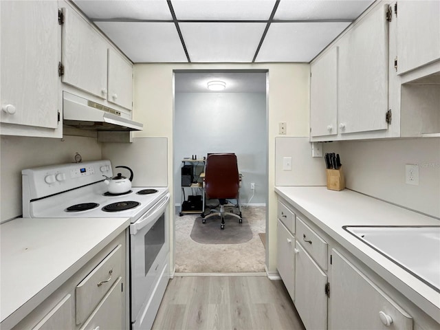 kitchen with electric range, light wood-style flooring, under cabinet range hood, a sink, and light countertops