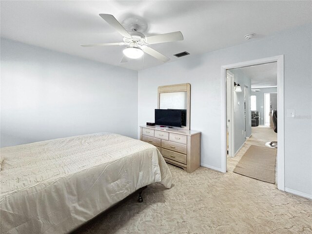 bedroom featuring visible vents, light carpet, baseboards, and ceiling fan