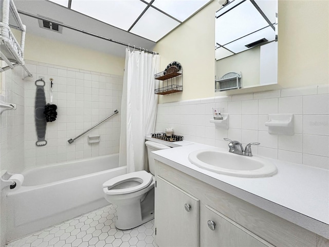 full bathroom with tile patterned flooring, tile walls, toilet, vanity, and shower / bathtub combination with curtain