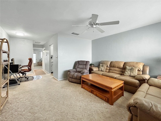 living area featuring visible vents, baseboards, light colored carpet, and ceiling fan