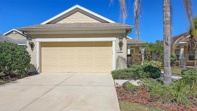 view of front facade featuring concrete driveway, an attached garage, and stucco siding