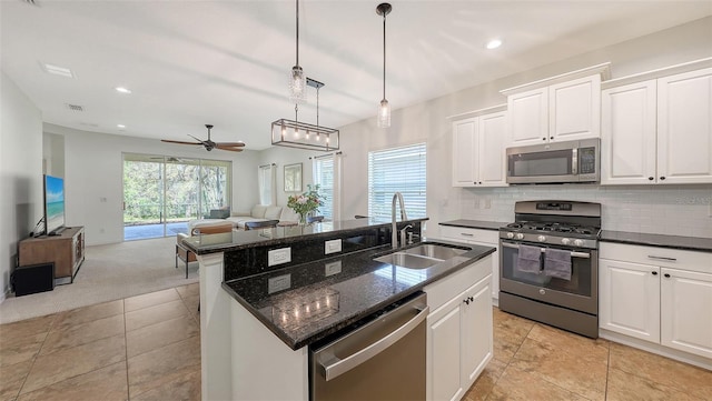 kitchen featuring a sink, stainless steel appliances, backsplash, and open floor plan