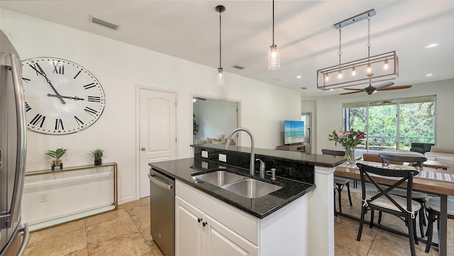 kitchen with visible vents, a center island with sink, a sink, open floor plan, and stainless steel appliances