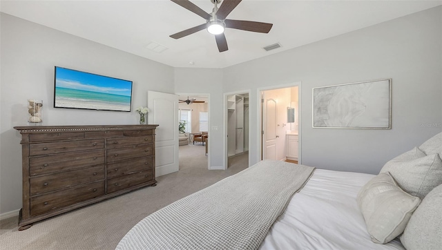 bedroom featuring visible vents, light colored carpet, connected bathroom, and a spacious closet