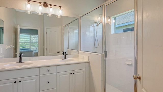 full bathroom with a shower stall, double vanity, and a sink