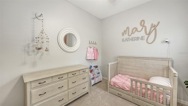 bedroom with a crib and light colored carpet