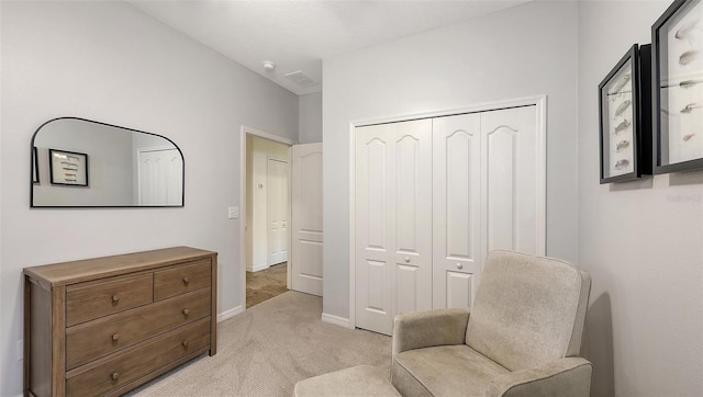 living area with visible vents, baseboards, and light colored carpet