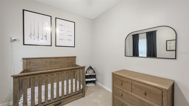 bedroom featuring carpet flooring, a nursery area, and baseboards